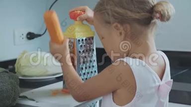 可爱的小女孩在家庭厨房的烤炉上<strong>摩擦</strong>胡萝卜。